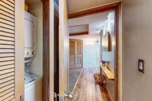 a hallway with a door open to a kitchen with wooden floors at The Landmark #2705 in Honolulu