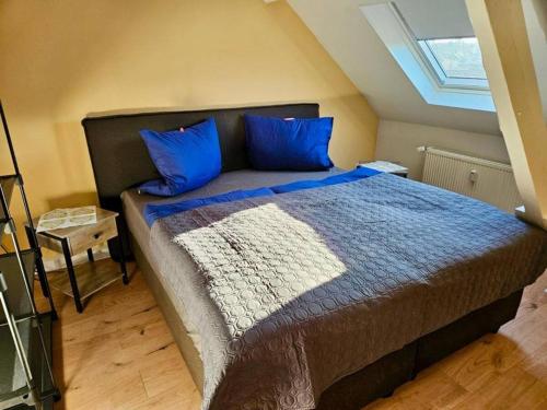 1 dormitorio con 1 cama grande con almohadas azules en PS120 02, en Stolberg