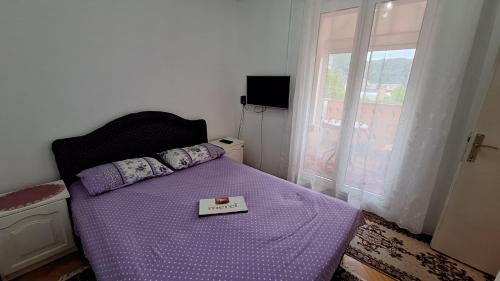 a bedroom with a purple bed with a box on it at Ana in Gradina