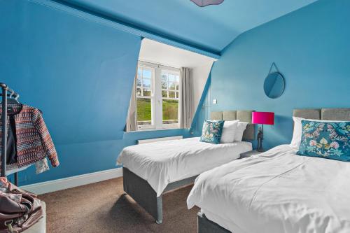 a blue room with two beds and a window at Harbour Heights Plymouth - Centrally located - Parking - Ocean City Retreats in Plymouth