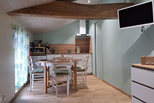 a kitchen with a table and chairs and a tv at Le P'tit Gîte d'Isa, 15 km du Puy du Fou in Mauléon