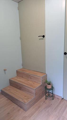 a room with stairs with a door and a table at Le P'tit Gîte d'Isa, 15 km du Puy du Fou in Mauléon