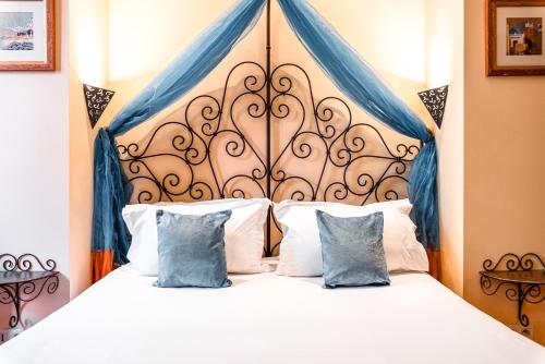 - une chambre avec un grand lit et des rideaux bleus dans l'établissement Villa Royale Montsouris, à Paris