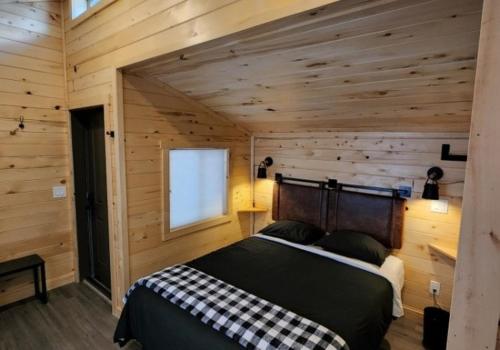 a bedroom with a bed in a room with wooden walls at Blue Buffalo Resort in Island Park
