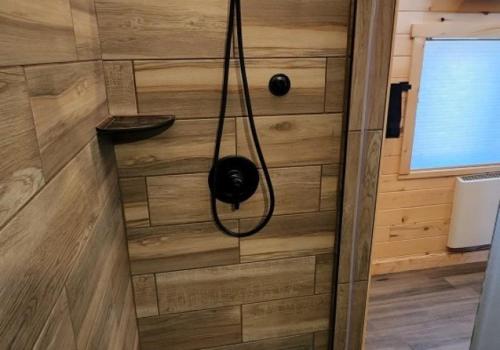 a shower in a bathroom with a wooden wall at Blue Buffalo Resort in Island Park