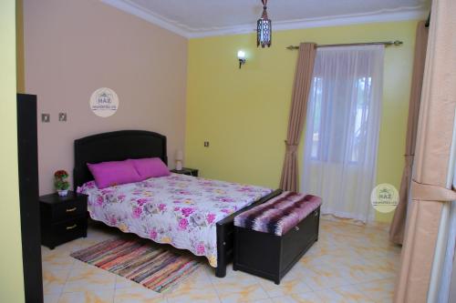 a bedroom with a large bed with a pink bedspread at Haz Holiday Home in Kampala