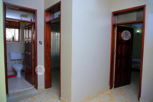 a bathroom with two doors and a toilet at Haz Holiday Home in Kampala