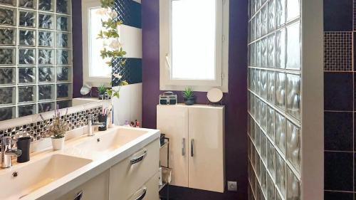 La salle de bains est pourvue de 2 lavabos et d'une paroi en verre. dans l'établissement Villa splendide à Villeneuve-Loubet avec piscine privée, à Villeneuve-Loubet