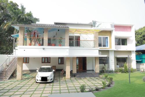 a white car parked in front of a house at Thekkanatt HomeStay in Palghat