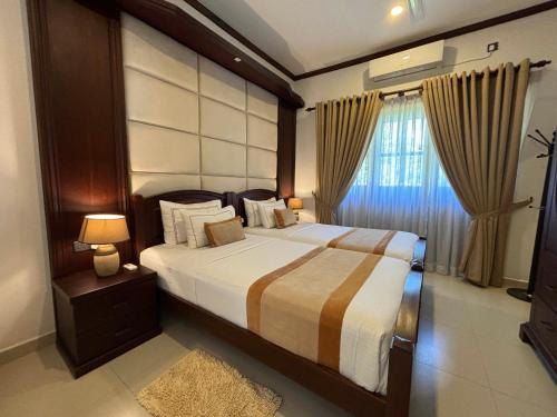 um quarto com uma cama grande e uma janela em Serenity Villa Digana em Kandy