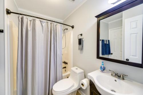 a bathroom with a toilet and a sink and a mirror at Charming Jacksonville Abode with Patio! in Jacksonville