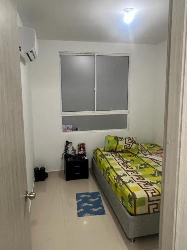 a small bedroom with a bed and a window at Casa amoblada festival vallenato in Valledupar