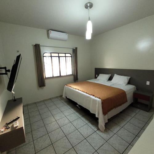 1 dormitorio con 1 cama y TV en Apartamento em Jardim Floresta, en Boa Vista