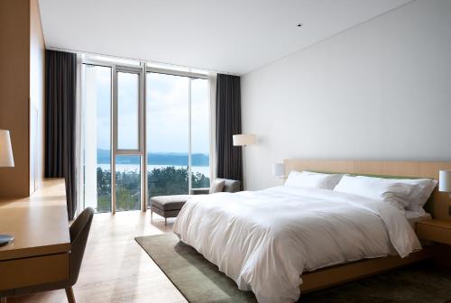 a bedroom with a large bed and a large window at SEAMARQ HOTEL in Gangneung