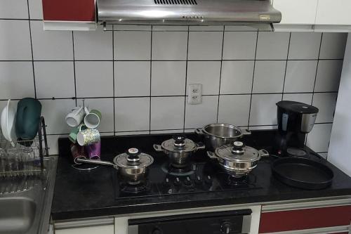 a kitchen counter with pots and pans on a stove at Apartamento em Jardim Floresta in Boa Vista