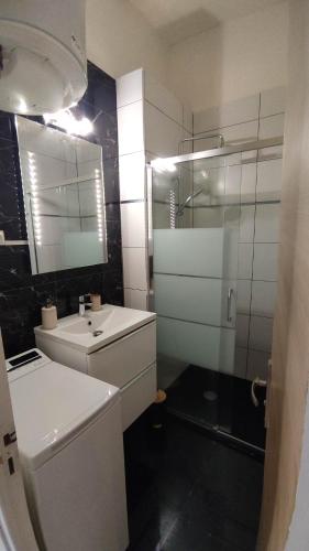 une salle de bain blanche avec un lavabo et un miroir dans l'établissement Set' en couleurs, à Sète