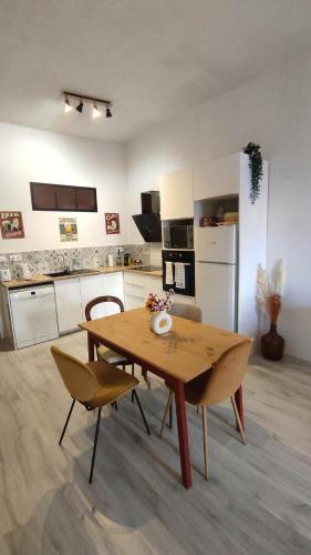 - une cuisine avec une table et des chaises en bois dans la chambre dans l'établissement Set' en couleurs, à Sète