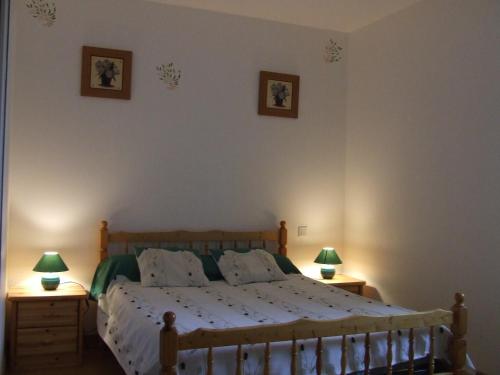 1 dormitorio con 1 cama de madera y 2 mesitas de noche en Les abris de la See, en Tirepied