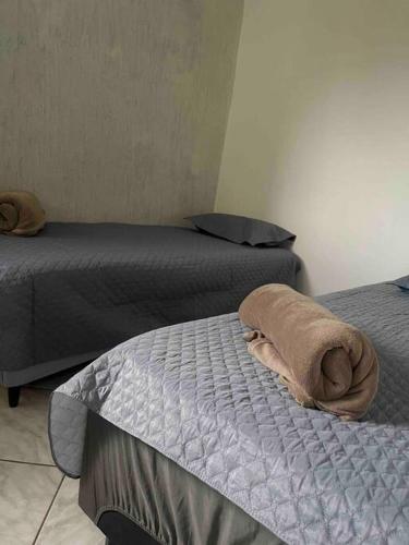 Apartamento 5 km do aeroporto في برازيليا: غرفة بسريرين ومنشفة على سرير