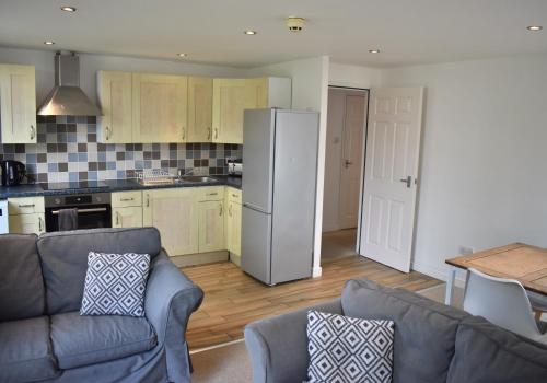 a kitchen with a couch and a refrigerator at Cawley Priory - Family Friendly, City Centre Apartment, Sleeps 4 in Chichester