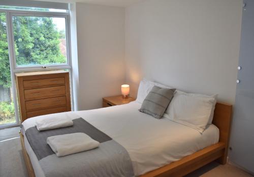 a bedroom with a large bed with a window at Cawley Priory - Family Friendly, City Centre Apartment, Sleeps 4 in Chichester