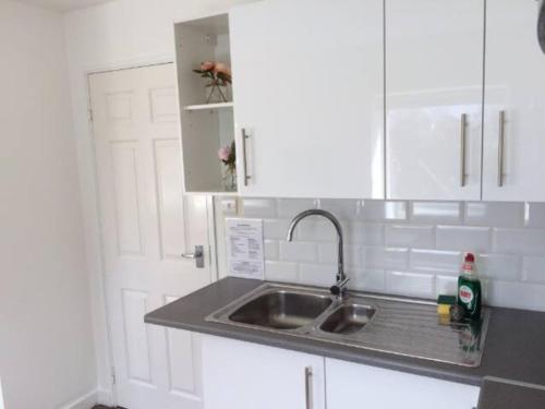 a kitchen with a sink and a white cabinet at Chichester Retreat - Quiet City Centre Apartment in Chichester