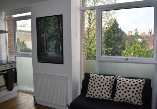 a living room with two windows and a couch at Canal Walk - Chichester City Centre Apartment in Chichester