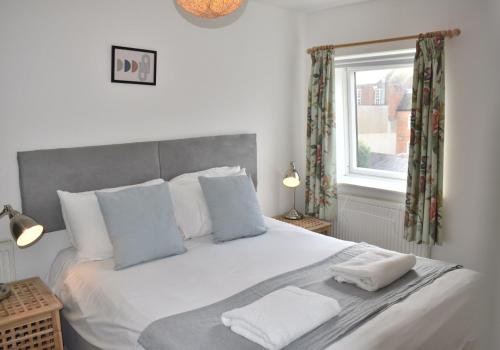 a bedroom with a white bed with two towels on it at Cathedral View - Chichester City Centre Top Floor Apartment in Chichester