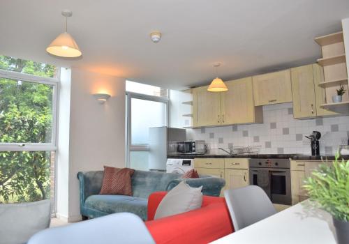 a living room with a couch and a kitchen at Chichester Quarters - Ground Floor, City Centre, 2 Bedroom Apartment in Chichester