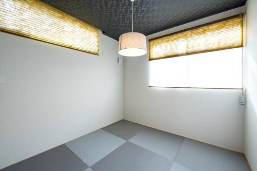 a room with white walls and a large window at Aile House Ⅰ in Takasaki