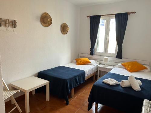 2 camas en una habitación con ventana en Apartamento junto a Es Clot de Sa Cera a 5 min Ciutadella, en Cala Santandria