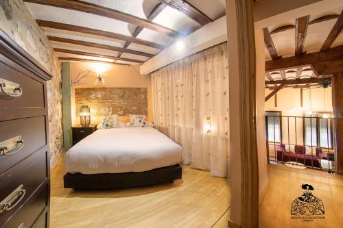 a bedroom with a large bed in a room at Casa de la Mezquita y Casa de Carretas MeninasCollection in Toledo