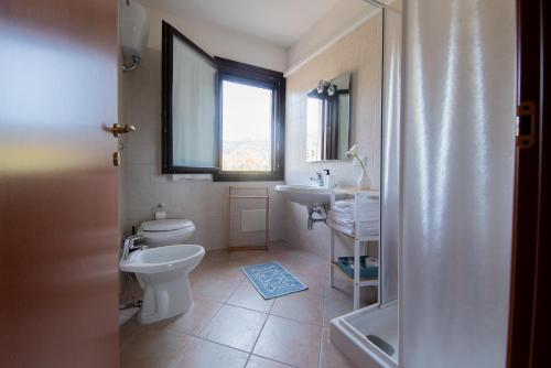 a bathroom with a toilet and a sink and a window at Casa Martina in Pula