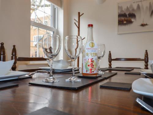 a bottle of beer and two wine glasses on a table at 8 Nicholas Court in Chester