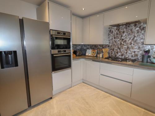 a kitchen with white cabinets and a stainless steel refrigerator at 8 Nicholas Court in Chester