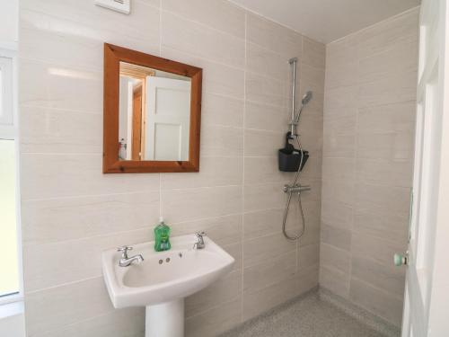 a bathroom with a sink and a mirror at Curragh Cottage 