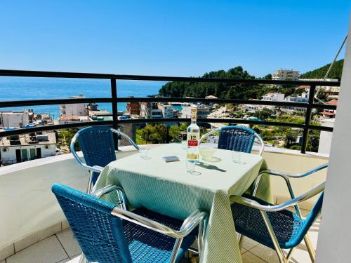 a table and chairs on a balcony with a view of the water at Sea view apartment, Himara in Himare