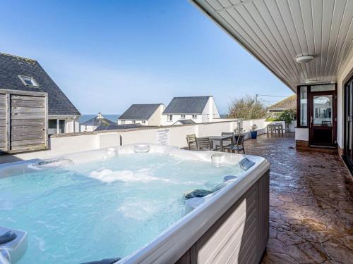 eine große Whirlpool-Badewanne auf der Terrasse eines Hauses in der Unterkunft Gwbert Holiday Cottages, Gwynt Y Mor in Cardigan