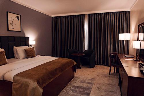 a hotel room with a bed and a desk at The Metropolitan Hotel Calabar in Calabar