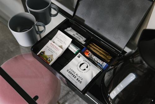 a box of books on a table with a coffee mug at Tower Bridge Road Rooms in London