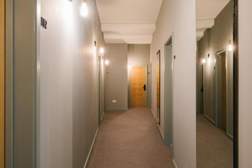 un couloir aux murs blancs et un couloir avec une porte dans l'établissement Tower Bridge Road Rooms, à Londres