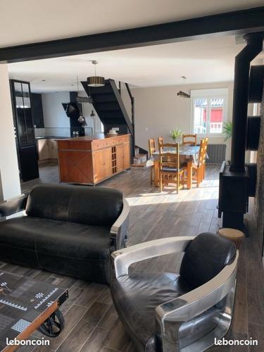 un salon avec un canapé et une salle à manger dans l'établissement L' Atelier sur les plages du débarquement, à Asnelles