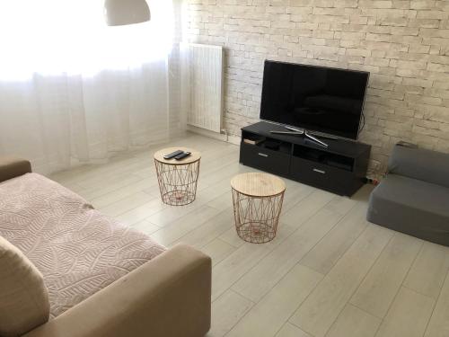uma sala de estar com um sofá e uma televisão de ecrã plano em Appartement Saint-Malo Centre - Arrivée autonome em Saint Malo