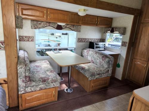 a kitchen and dining area in an rv at Camping Beaurivage 1- Pret à camper entièrement équipée pour 6 personnes in Routhierville