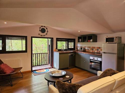 a large living room with a couch and a table at Treetops Lodge, private parking & garden in Truro