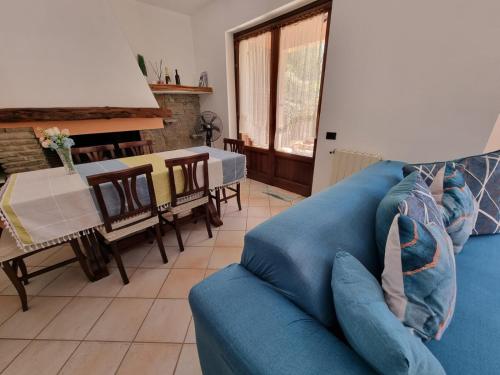 ein blaues Sofa im Wohnzimmer mit einem Tisch in der Unterkunft MAREMONTI Poggio Dei Pini Capoterra in Capoterra