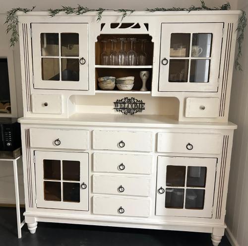 a white dresser with glass doors at Paisanas Wisemans Ferry in Wisemans Ferry