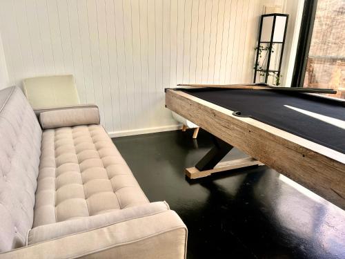 a pool table in a living room with a couch and a pool table at Paisanas Wisemans Ferry in Wisemans Ferry