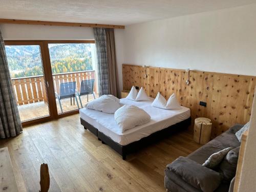 um quarto com 2 camas e uma grande janela em Hotel Elisabeth Panorama em Antermoia