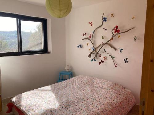 une chambre avec une branche d'arbre sur le mur dans l'établissement Villa avec piscine, au calme et en pleine nature!, à Pierrevert